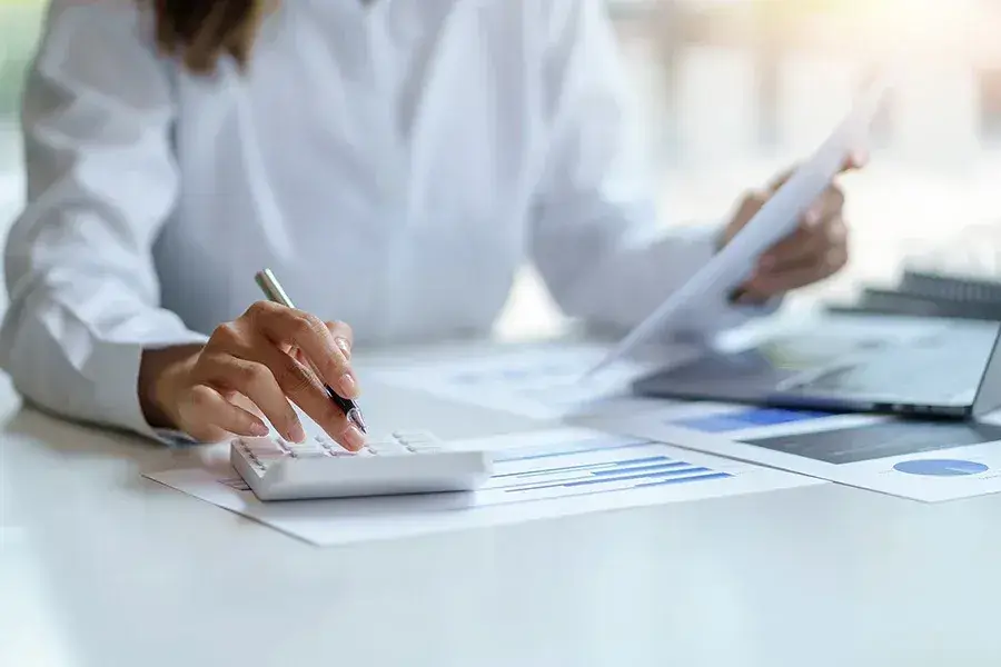 Kalkylator och ekonomiska rapporter på skrivbord – ekonomisk förvaltning för BRF