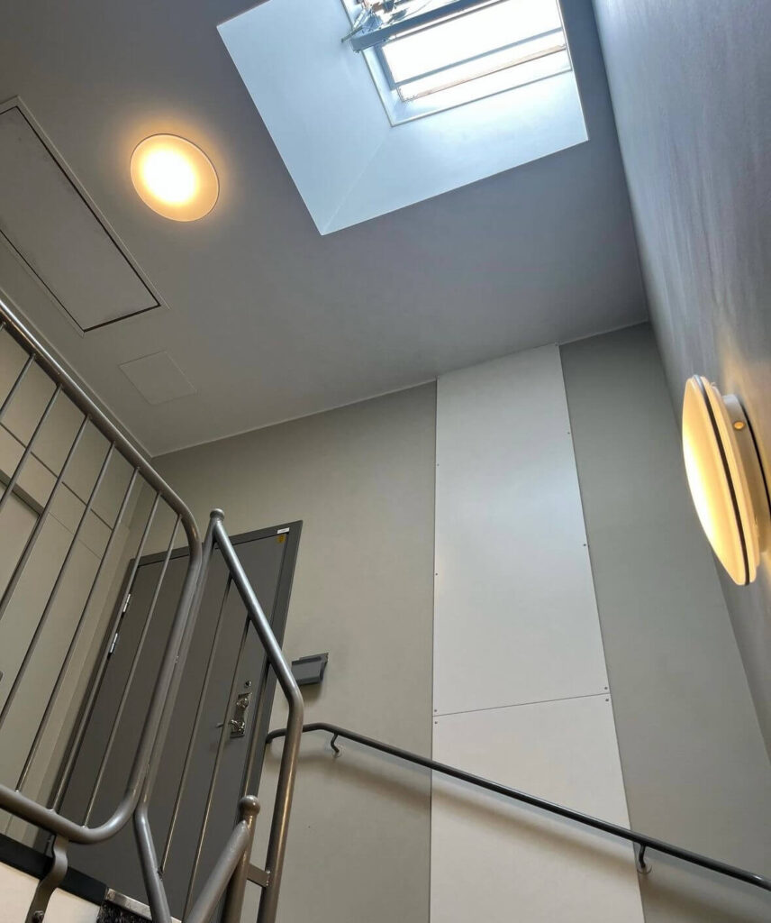 Välskött trapphus med takfönster och modern energioptimerad belysning i flerbostadshus eller BRF – fastighetsskötsel i Stockholm