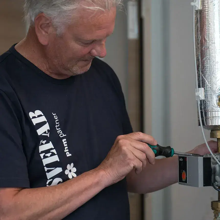 SVEFABs fastighetstekniker utför underhåll av cirkulationspump i teknikrum