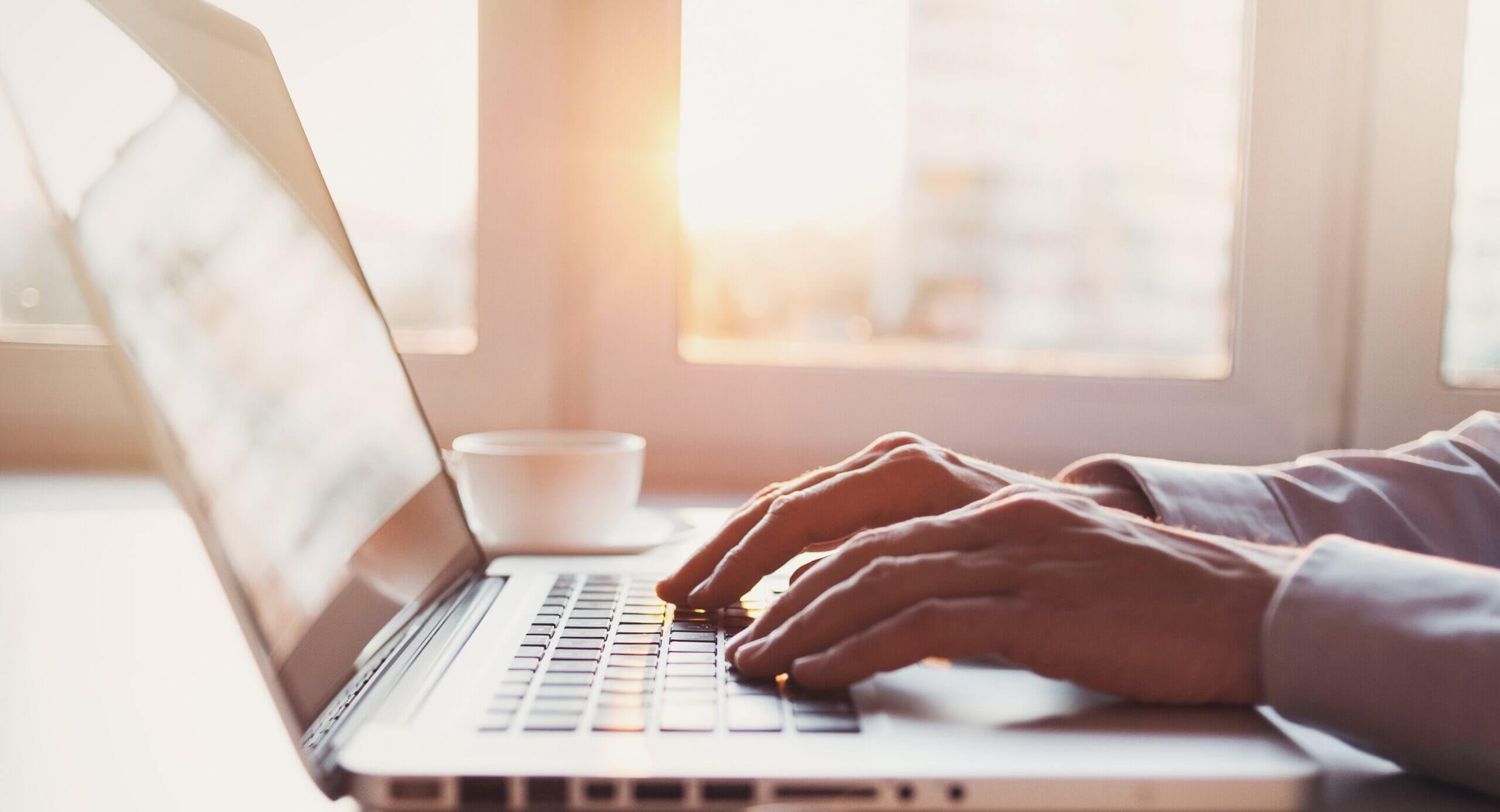 Person skriver offertförfrågan på laptop i solljus – begär offert från SVEFAB