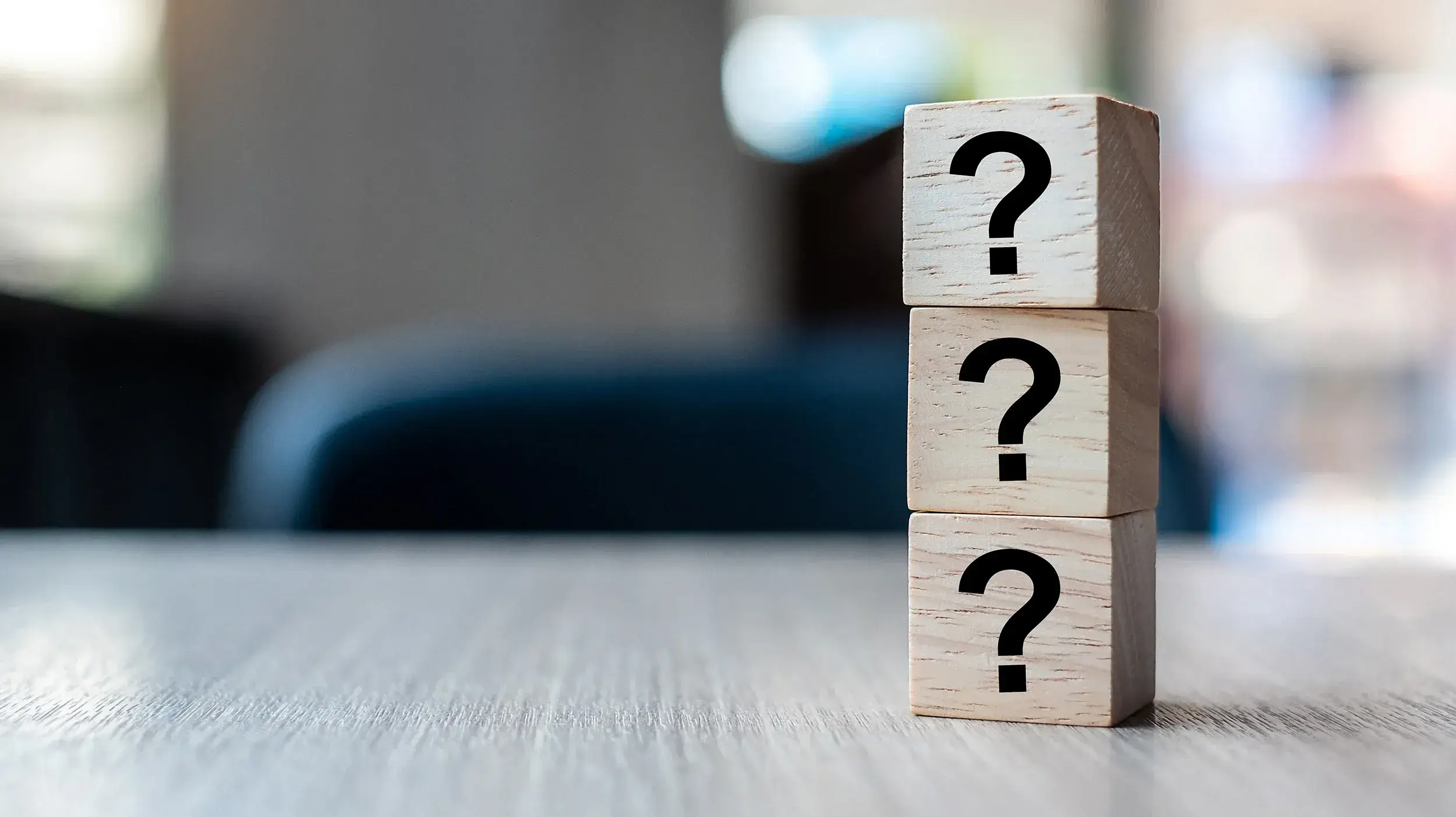 Tre klossar står staplade på varandra med varsitt frågetecken skrivet på sidan av klossen.